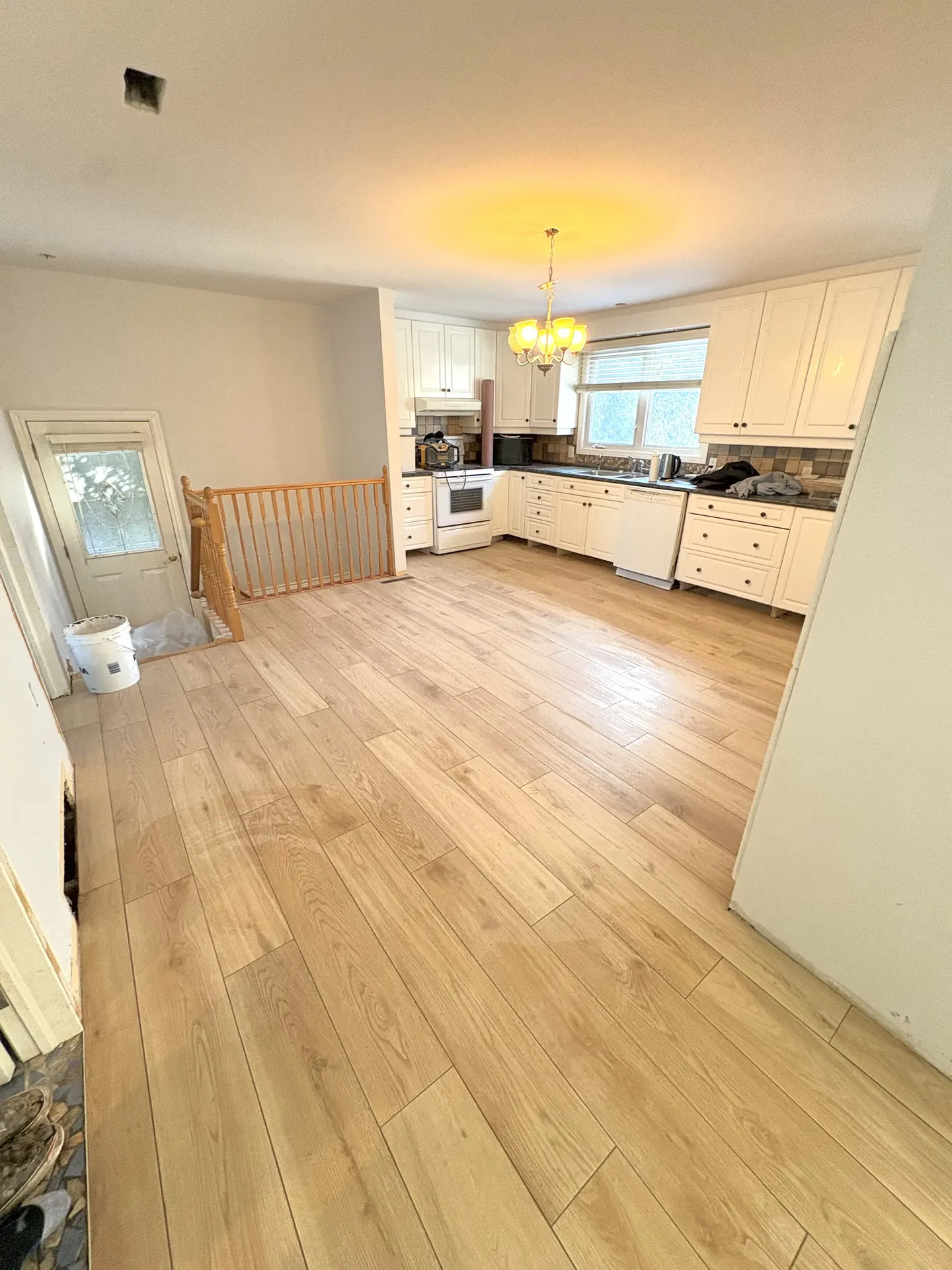 Chambre rénovée avec murs blancs et plancher de bois franc