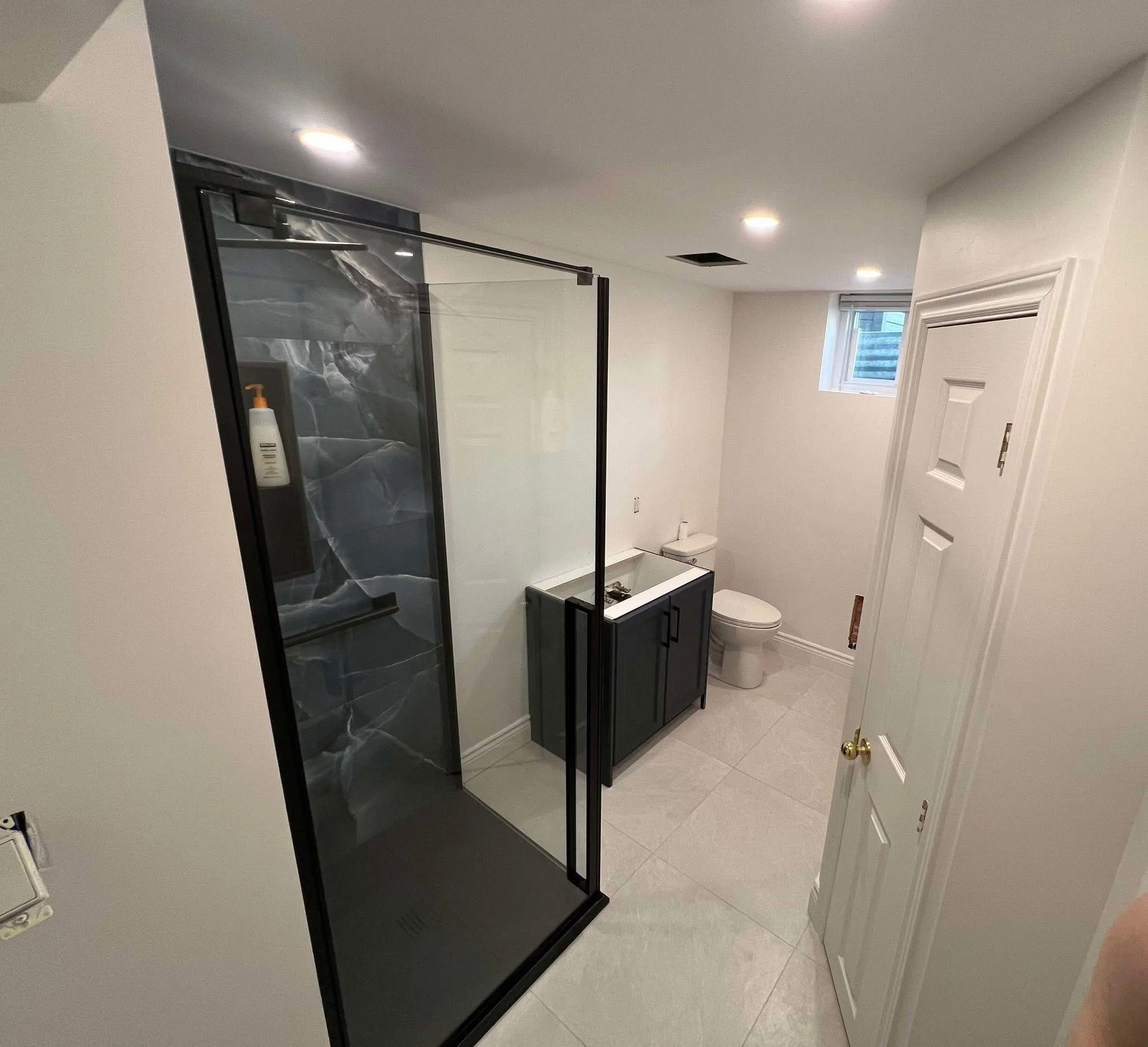 Salle de bain de sous-sol avec douche en verre et meuble-lavabo — Rénovation clé en main en Outaouais par BEGIN Construction