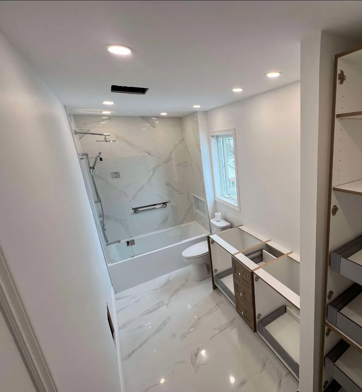 Salle de bain en marbre blanc avec baignoire et douche — Rénovation clé en main en Outaouais par BEGIN Construction