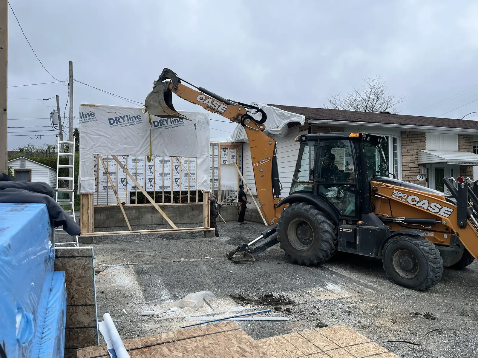 Agrandissement et garage attenant en construction à Val-des-Monts — enveloppe DRYline et excavatrice sur place