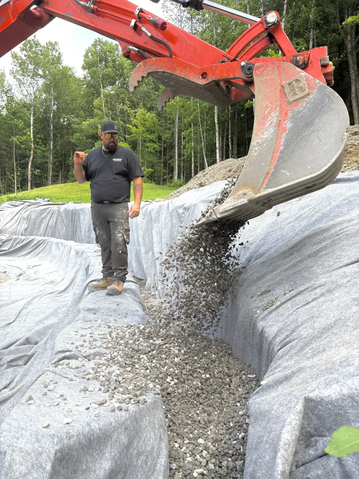 Pose de drainage et remblai en pierre concassée par l'équipe BEGIN Construction en Outaouais